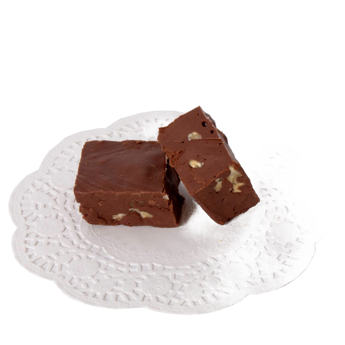 Two pieces of creamy chocolate fudge with visible nut pieces, presented on a decorative white paper doily, showcasing a handcrafted treat from USA-made snack collections.