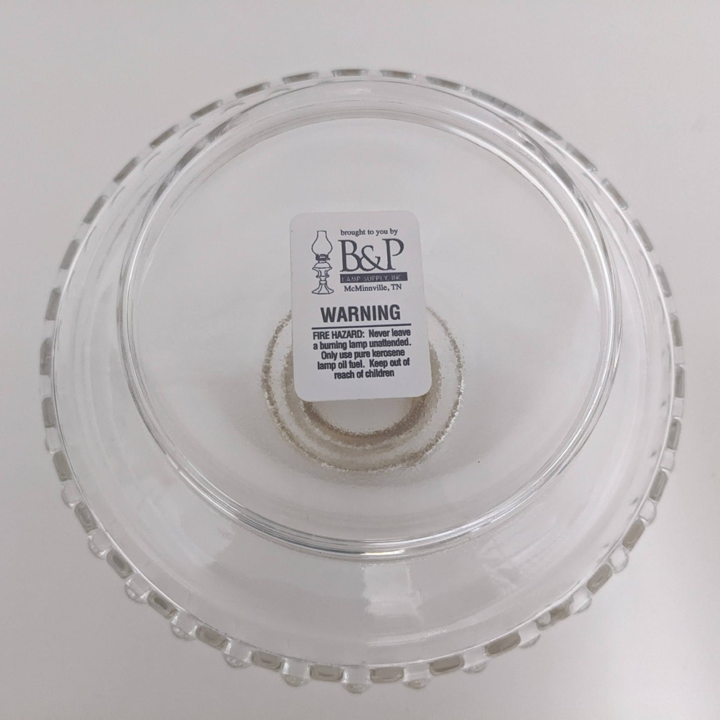 Clear glass lamp font with a scalloped edge, featuring a central wick holder, crafted for use in lamps & lighting, oil lamps, wall lamps, and popular best sellers collections.