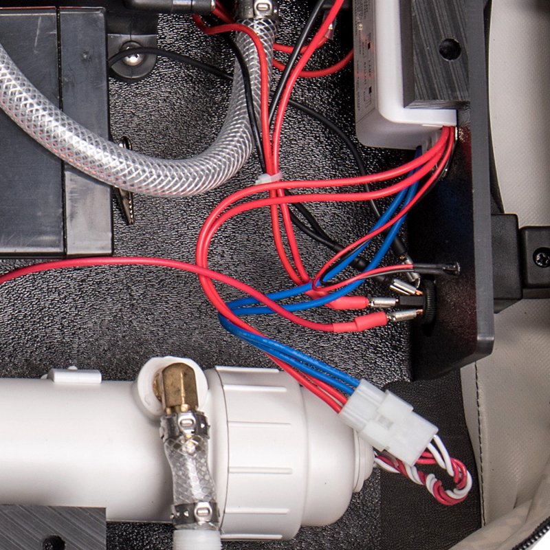 Close-up view of electrical wiring and components inside an appliance, featuring red and blue insulated wires connected to terminals, part of replacement parts for water treatment and emergency supplies.
