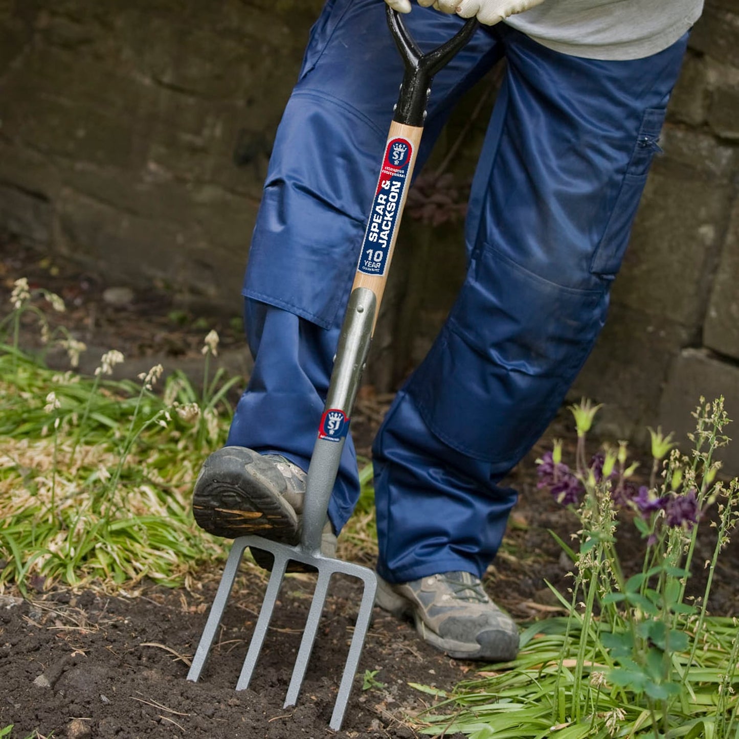 Gardener using a professional digging fork with solid forged carbon steel tines and wooden handle, designed for farm, garden, and lawncare tasks in small spaces and best sellers collections.