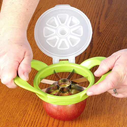 Green apple wedge cutter with pop-up cover and stainless steel blades slicing an apple on a wooden surface, featured in Farm, Garden & Tool and Kitchen & Food collections.