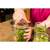 Hands using a metal lid to seal a handcrafted regular-mouth canning jar filled with fresh green beans, part of heritage and lifestyle books and best sellers collections.