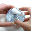 Hands holding a clear and white nut and hard spice grinder with a crank handle, designed for Kitchen & Food, Brewing Coffee and Tea, and Best Sellers collections.