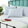 Soft, generously filled down pillows with white and blue striped covers arranged on a classic iron bed frame in a cozy bedroom setting, featured in Home & Decor and Home Textiles collections.
