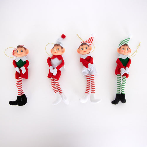 Four posable retro-style Christmas elf ornaments in red, white, and green festive outfits with striped tights, fabric bodies, and hanging cords, featured in holiday decor collections.