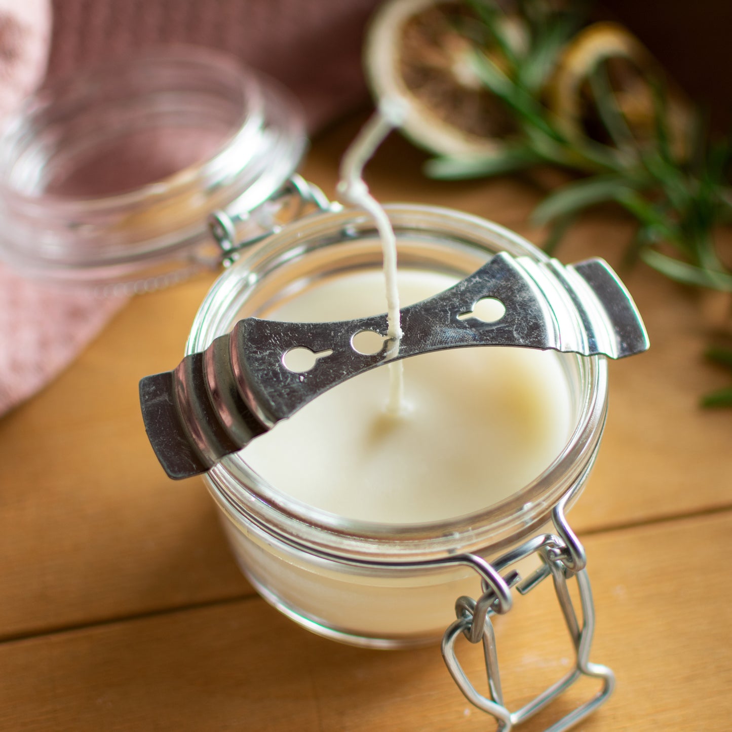 Close-up of a glass mason jar candle with a metal wick holder securing a cotton wick, highlighting parts and accessories for lamps and lighting in the best sellers and wicks and mantles collections.