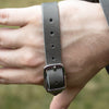 Close-up of a hand wearing a strong double wrist strap with a metal buckle, featuring a leather palm pad, part of Farm, Garden & Tool and USA Made collections.
