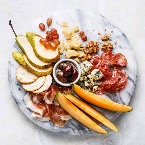 Round polished marble serving tray with a smooth surface, featuring an assortment of snacks arranged for elegant presentation, ideal for Kitchen & Food and Dinnerware collections.