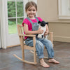 Young girl sitting barefoot on a handcrafted wooden children's rocker made of unfinished oak, holding a stuffed animal, in a bright room with natural light, suitable for Toys, Books & Games, USA Made, Amish Made, Children's Toys, Wooden Toys, Best Sellers, and Promo Eligible collections.