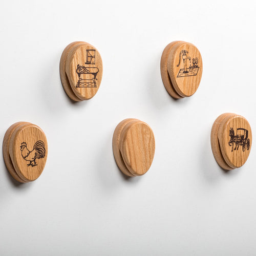 Set of five handcrafted oak towel holders with a protective clear finish, featuring unique engraved motifs including a vintage sewing machine, water pump with flowers, rooster, plain, and horse-drawn buggy, made in USA and Amish Made, ideal for Home & Decor, Household Helpers, USA Made, Amish Made, Best Sellers, and Promo Eligible collections.
