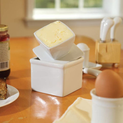 Square porcelain butter keeper with lid holding a half cup of soft butter, handcrafted for countertop use in Kitchen & Food, Specialty Equipment, and Storage collections.