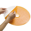 Hands peeling homemade orange fruit leather from a flexible round sheet designed to fit Presto dehydrator trays, featured in Kitchen & Food and Food Preservation collections.