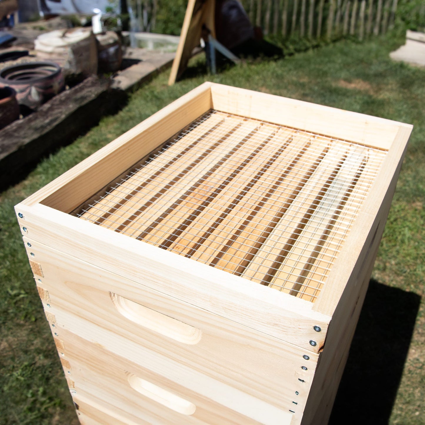 Handcrafted 10-frame wooden candy board feeder made in the USA with a slatted top for hive ventilation, designed for beekeeping supplies in farm and garden collections.