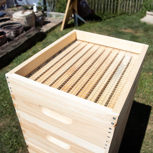 Handcrafted 10-frame wooden candy board feeder made in the USA with a slatted top for hive ventilation, designed for beekeeping supplies in farm and garden collections.