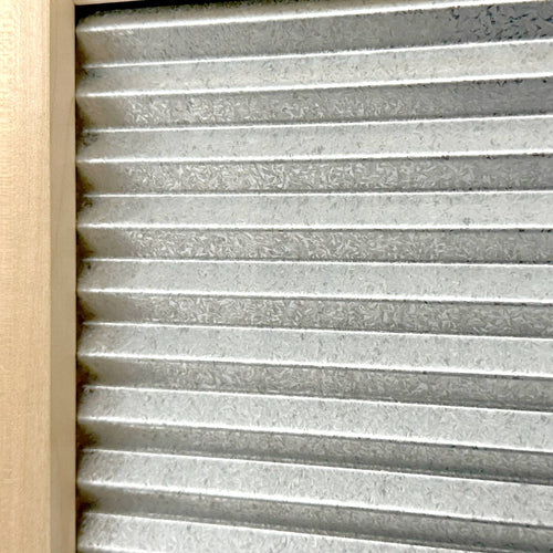 Close-up of a galvanized metal washboard with wavy ridges set in a mortised wooden frame, designed for effective stain removal, part of Laundry Supplies and USA Made collections.