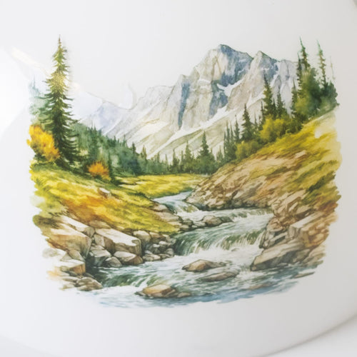 Handcrafted glass lamp shade featuring a scenic watercolor illustration of a mountain stream with evergreen trees, rocks, and flowing water, perfect for lamps and lighting collections.