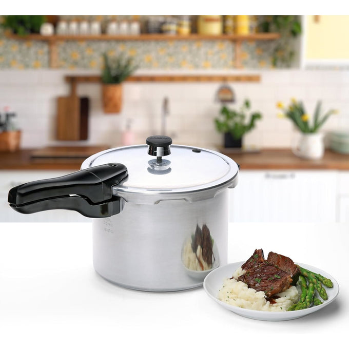 Polished aluminum pressure cooker with black handle on a kitchen counter next to a plate of mashed potatoes, steak, and asparagus, featured in Kitchen & Food, Cookware, Pots and Pans, Best Sellers, and Promo Eligible collections.