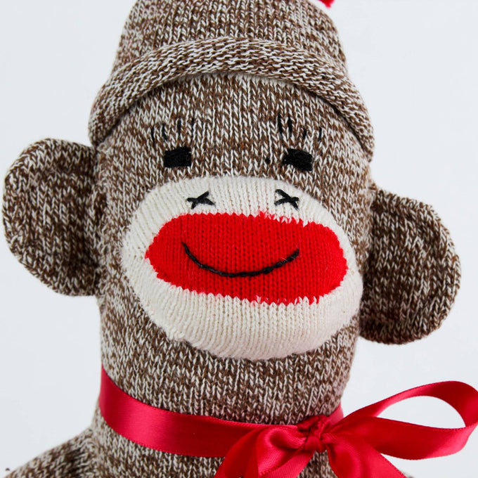 Handcrafted sock monkey made in USA from brown and cream knit socks, featuring a red knitted mouth, black stitched eyes, and a red ribbon bow, part of Toys, Books & Games and Children's Toys collections.