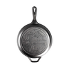Black cast iron frying pan with handle, featuring an embossed cozy cabin scene on the cooking surface, ideal for camping, kitchen, and cookware collections emphasizing USA made quality.