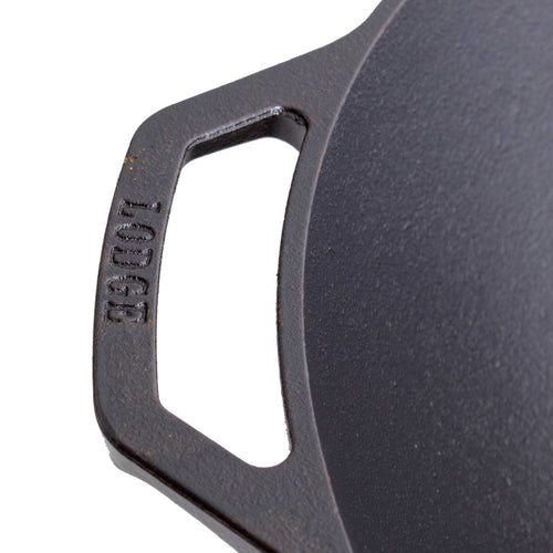 Close-up of a cast iron wok handle with embossed brand name, showcasing sturdy construction and seasoning, ideal for kitchen use in cookware and cast iron collections.