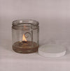 Handcrafted clear glass olive oil lamp burning with a bright flat wick inside a 16 oz jar, featuring a steel wick holder and white lid, ideal for Lamps & Lighting, USA Made, Oil Lamps, and Olive Oil Lamps collections.