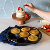 Handcrafted cast iron mini cake pan with six golden cakes, a small decorated cake on a wooden stand, fresh strawberries, and blueberries, featured in Kitchen & Food, Cast Iron, and USA Made collections.