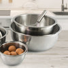 Stacked polished stainless steel mixing bowls with a whisk in the top bowl and fresh eggs in the smallest bowl, ideal for Kitchen & Food, Cookware, Baking Supplies, and Best Sellers collections.