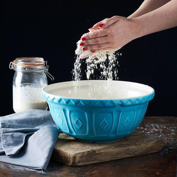 Handcrafted turquoise earthenware mixing bowl with embossed geometric pattern, used for baking with flour and a glass jar on a wooden surface, perfect for Kitchen & Food and Cookware collections.