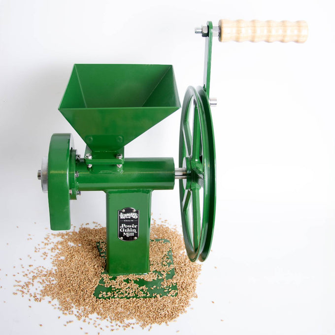 Green hand-crank grain mill with sturdy cast iron body and wooden handle, surrounded by whole grains, ideal for kitchen, farm, and emergency food supplies.
