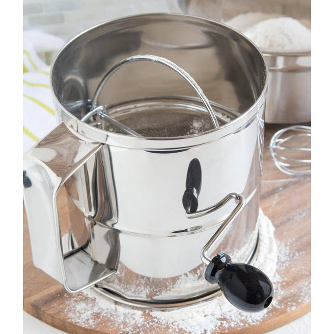 Handcrafted stainless steel 8-cup flour sifter with a black crank handle, designed to aerate and break up lumps in flour, featured in Kitchen & Food and Baking Supplies collections.