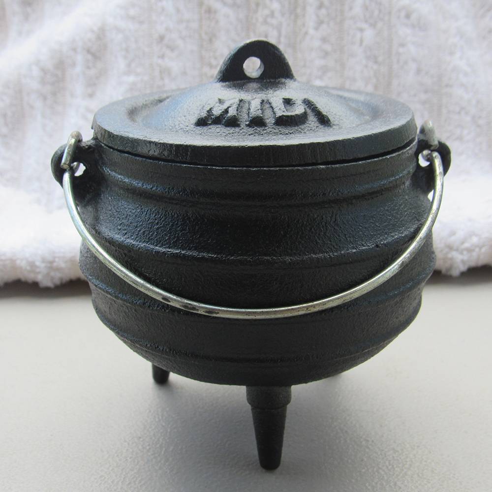 Small cast iron pot with three built-in legs and attached metal handle, seasoned with flaxseed oil, ideal for outdoor dining and kitchen use, in Kitchen & Food and Cast Iron collections.