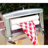 Handcrafted metal clothes wringer with white rollers gently removing water from a red and white patterned fabric, featured in Laundry Supplies and Homesteading collections.