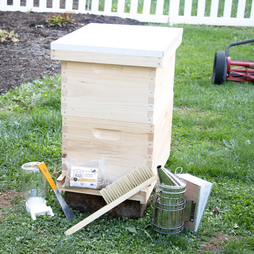 Natural wood 8-frame beehive kit with white cover, including essential beekeeping tools arranged outdoors on grass, showcasing handcrafted quality for Farm, Garden & Tool, Beekeeping Supplies, and 8-Frame Hives collections.