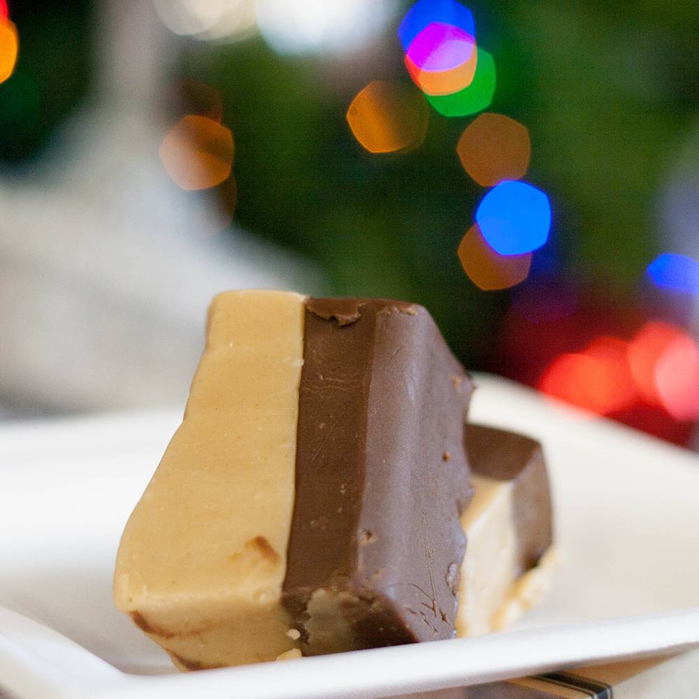 Two handcrafted fudge pieces with creamy caramel and rich chocolate layers on a white plate, featured in Kitchen & Food, Snacks and Sweets, USA Made, Best Sellers, and Promo Eligible collections.