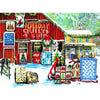Colorful winter scene of handmade holiday quilt patterns displayed outside a red barn and yellow country store, showcasing handcrafted, Amish-made designs in a festive, snowy setting.