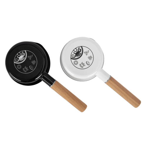 Two Petromax enamel pans for outdoor cooking in black and white, each featuring a wooden handle and decorative symbols on the base, perfect for camping and cookware collections.