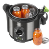 Electric 12-quart stainless steel digital pressure canner with black handles and green accent on lid, shown with glass jars of preserved sliced carrots, ideal for food preservation in kitchen and canning collections.