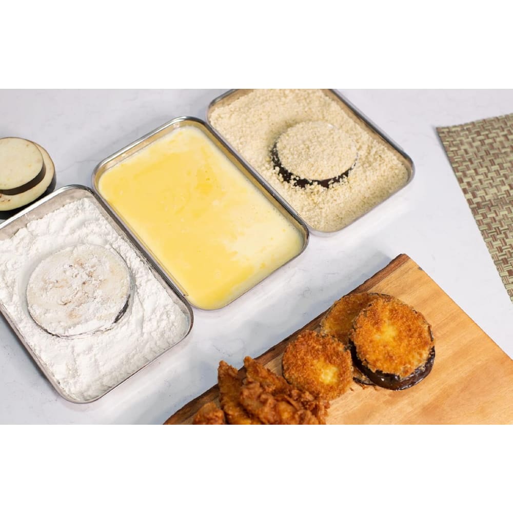 Three attachable stainless steel trays arranged with flour, beaten egg, and breadcrumbs for a no-mess breading process, shown with breaded eggplant and chicken pieces, ideal for Kitchen & Food and Cookware collections.