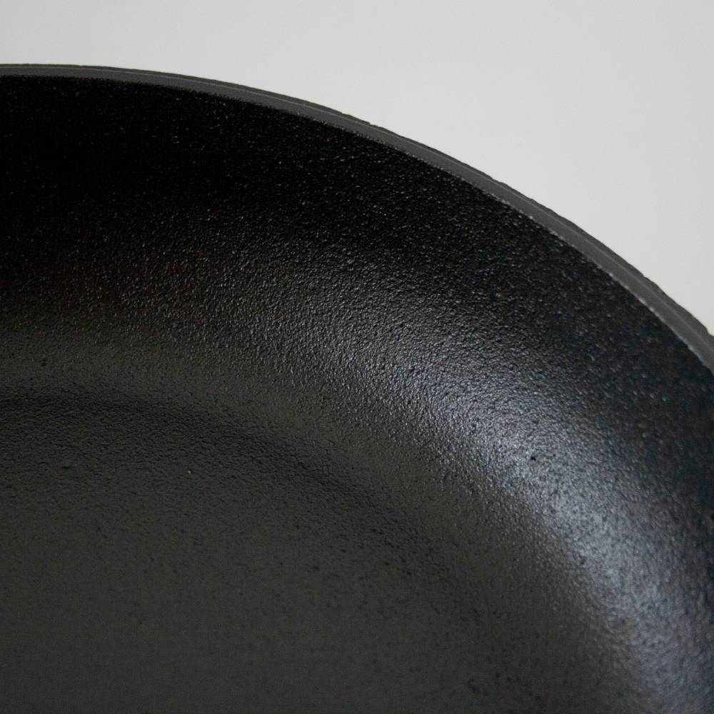 Close-up of the seasoned cooking surface of a handcrafted cast iron skillet, part of Kitchen & Food, Cookware, Cast Iron, USA Made, Best Sellers, and Promo Eligible collections.
