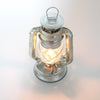 Compact galvanized metal lantern with a glowing light inside, designed for reliable use in camping, emergency supplies, farm, garden, and outdoor lighting collections.