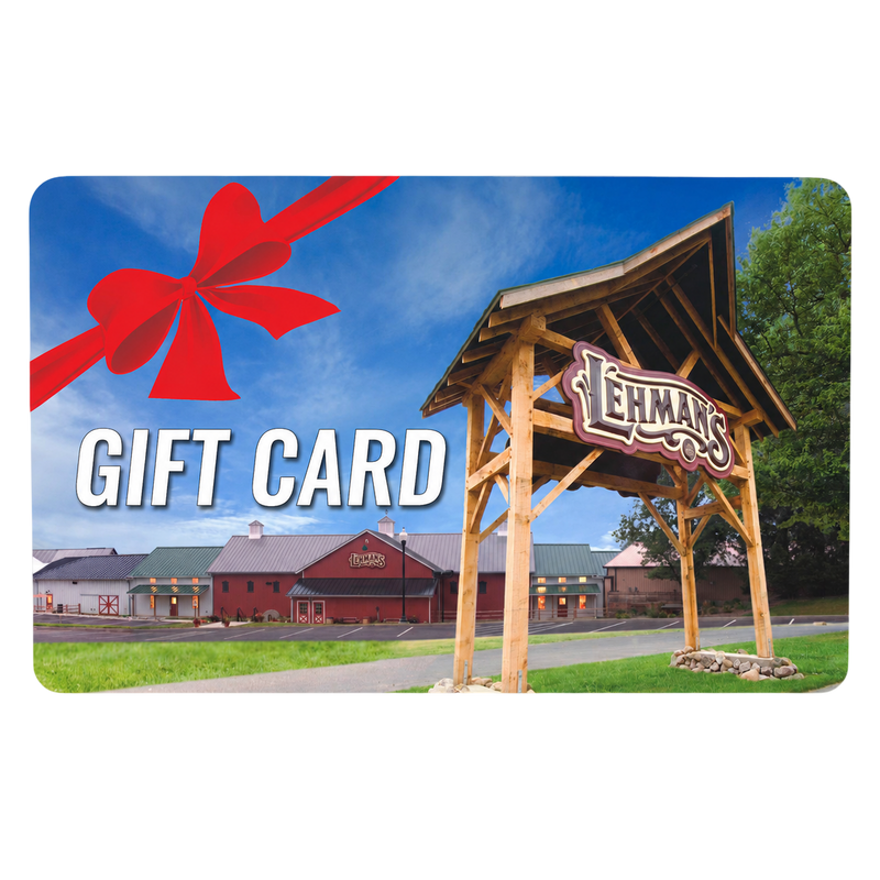 Lehman's store entrance with a large wooden sign under a blue sky, overlaid with bold white text reading Gift Card and a festive red ribbon bow, featured in Best Sellers.