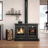 Black enameled cast iron wood cook stove with visible fire and oven cooking bread, featured in a modern kitchen setting with firewood stored nearby, part of Stoves and Cookstoves collections.
