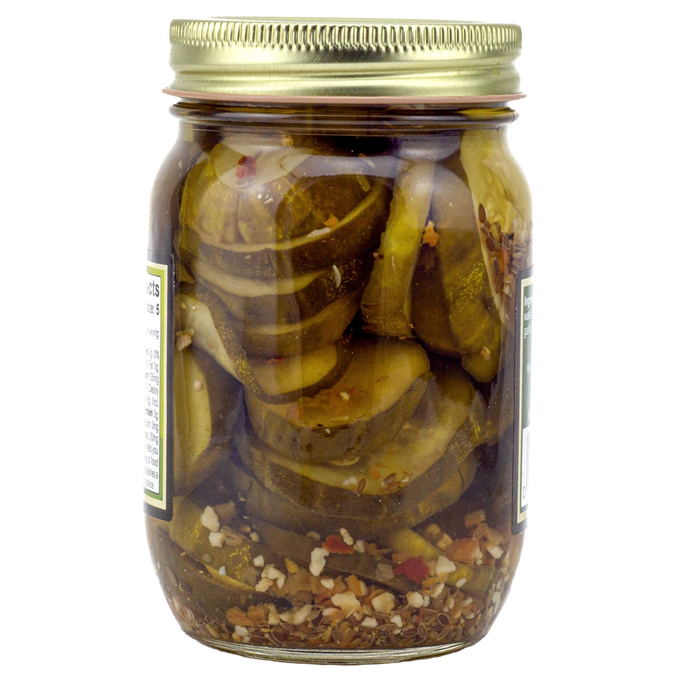 Clear glass jar filled with sliced pickles blended with hot habanero peppers and spices, sealed with a gold lid, handcrafted and made in USA, ideal for kitchen pantry collections.