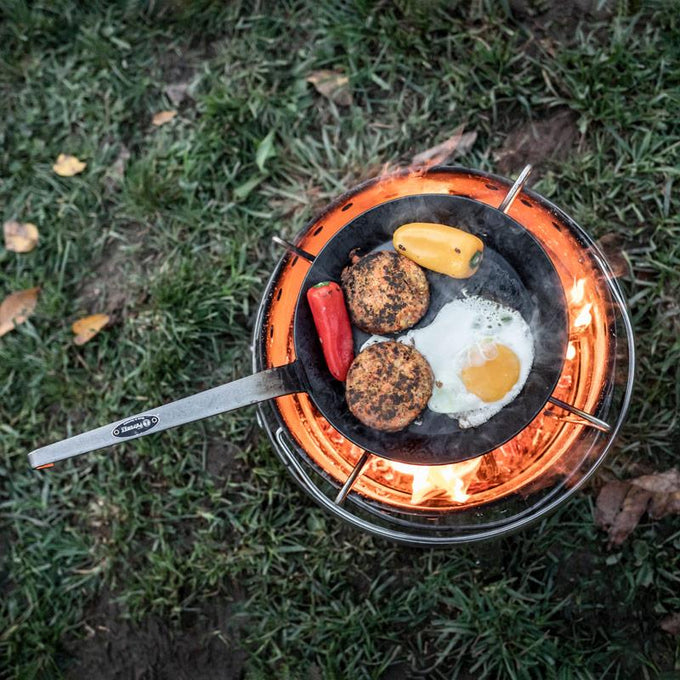 Hand-forged wrought iron pan with a long handle cooking burgers, egg, and peppers over an open flame, perfect for Farm, Garden & Tool, Kitchen & Food, Camping, Cookware, Pots and Pans, Best Sellers, and Promo Eligible collections.
