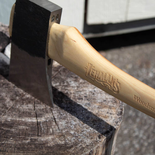 Close-up of a sharp carbon steel axe head with a smooth, handcrafted Amish-made hickory handle engraved with branding, resting on a weathered wood chopping block, part of Farm, Garden & Tool and USA Made collections.