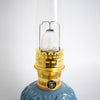 Close-up of a handcrafted Aladdin oil lamp burner with polished brass elements and clear textured chimney, featured in Lamps & Lighting, Oil Lamps, Table Lamps, Best Sellers, and Promo Eligible collections.