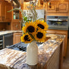 Handcrafted cream-colored stoneware milk bottle filled with fresh sunflowers and greenery, displayed on a granite kitchen island in a rustic home setting, suitable for Home & Decor, Kitchen & Food, and USA Made collections.