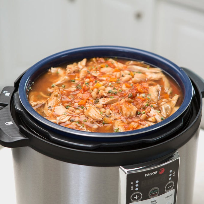 Handcrafted all-natural slow cooker soup with chunks of tender chicken, beans, and vegetables cooking in a modern stainless steel electric cooker, ideal for Kitchen & Food and Gluten Free collections.
