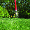 Handcrafted long red steel weeder with ergonomic handles pulling dandelion weeds from a green lawn, featured in Farm, Garden & Tool, Digging and Cultivating, Garden Accessories, and Best Sellers collections.