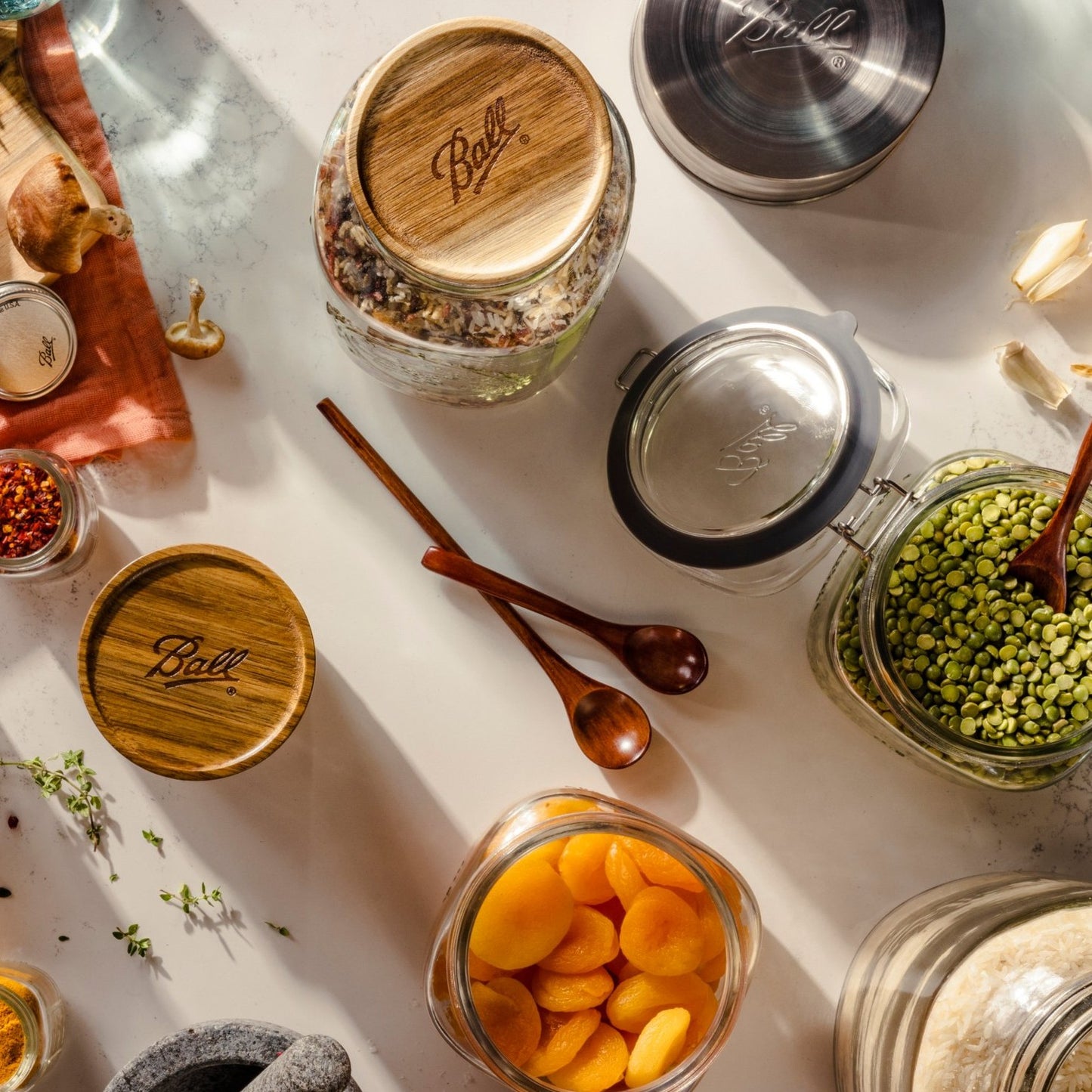 Set of three handcrafted acacia wood storage lids with Ball branding, airtight and stackable, displayed on jars with dried foods, perfect for Kitchen & Food and Storage and Serving collections.